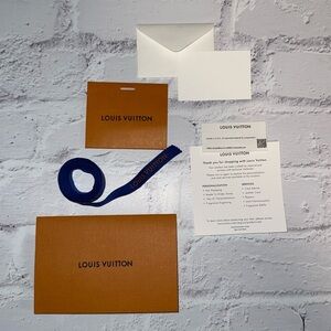 Louis Vuitton paperwork holder and blank thank you card with ribbon.